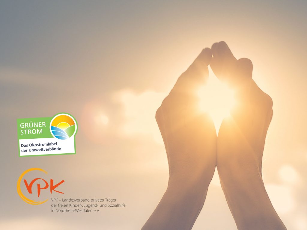 Zwei Hände, durch die die Sonne scheint und die Logos vom Grüner Strom Label e.V. und dem VPK (Landesverband privater Träger der freien Kinder etc.-Hilfe)